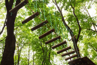 urgan halat Parkı, ağaçlar yeşil yaprakları ile birlikte tehlikeli teleferik