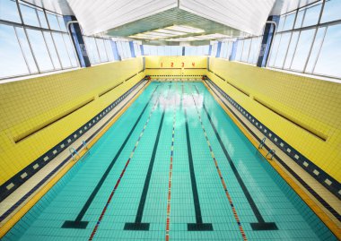 Büyük kapalı yüzme havuzu, dört bowling pisti, sarı duvarlar, fayanslar.