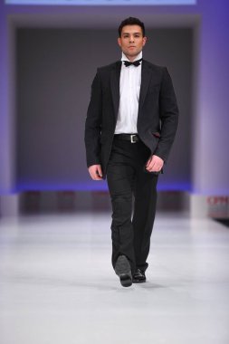 22 Şubat 2011 'de Rusya' nın başkenti Moskova 'da düzenlenen Doğu Avrupa pazarının önde gelen moda fuarlarından biri olan Moskova Koleksiyon Premiere Moskova' da Slava Zaytzev 'in siyah takımını giyen adam podyumda yürüyor..