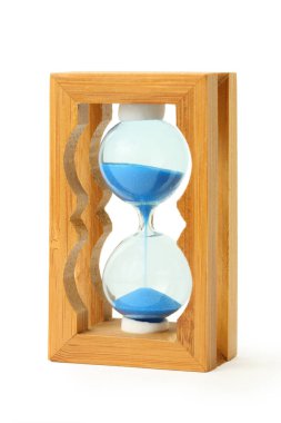 Saf mavi kum beyaz üzerine izole edilmiş ahşap kum saatine düşer.