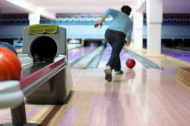 Man exactly throws up ball on skittles in bowling club clipart