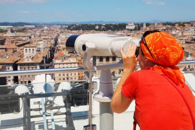 Woman in red wear looking through big binoculars, color panorama of Rome from altar of fatherland, catholic basilics, streets and houses, Italy clipart