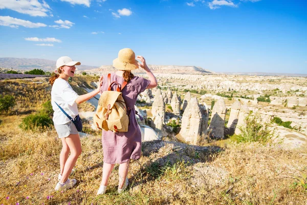 土耳其卡帕多西亚的母女家庭欣赏岩石形成的山谷和仙女烟囱的背景 — 图库照片