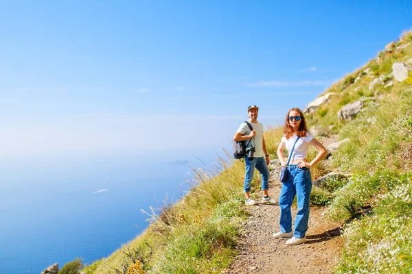 Teenage girl and her father enjoying stunning view over Amalfi coast in Italy while hiking picturesque Path of the Gods trail