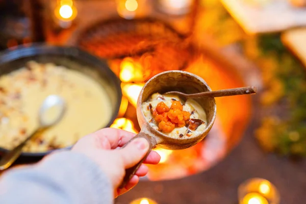 stock image Delicious Lappish baked cheese with cloudberry jam served in wooden bowl in lappish hut next to open fire