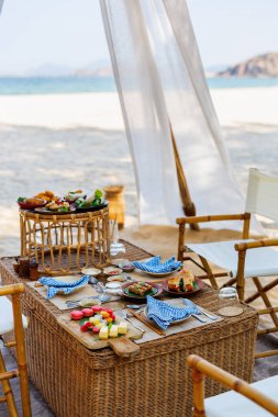 Luxury picnic on beautiful white sand beach at sunset