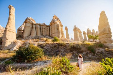 Young woman walking in Love valley in Cappadocia Turkey among rock formations and fairy chimneys