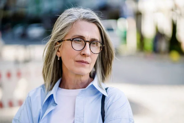 在欧洲的一个城市里 一个有着银发眼镜的可悲的成熟女人 在老年和老年人的心理健康问题上描绘了孤独 沮丧和绝望的感觉 高质量的 — 图库照片