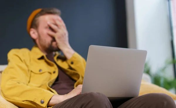 Homem Sentado Sofá Com Laptop Mostrando Gesto Facepalm Com Mão — Fotografia de Stock