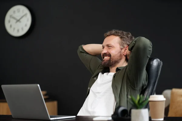 사무실 의자에서 휴식을 취하는 행복하고 미소짓는 커피를 마시면서 노트북 컴퓨터로 — 스톡 사진