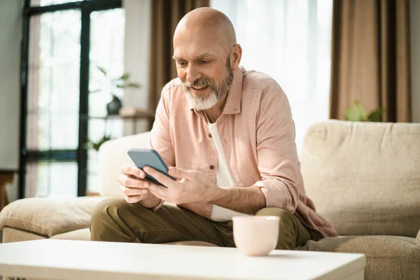 Evdeki Koltukta Otururken Telefondaki Mutlu Orta Yaşlı Adam Mesajı Yüksek — Stok fotoğraf