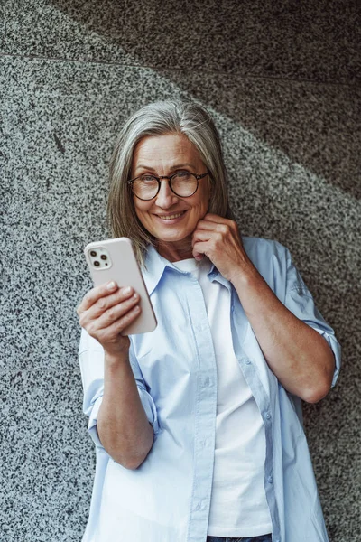 老年交流的概念 成熟的老年妇女使用手机发短信和上网 妇女积极参与技术 并希望在数字时代保持联系 — 图库照片