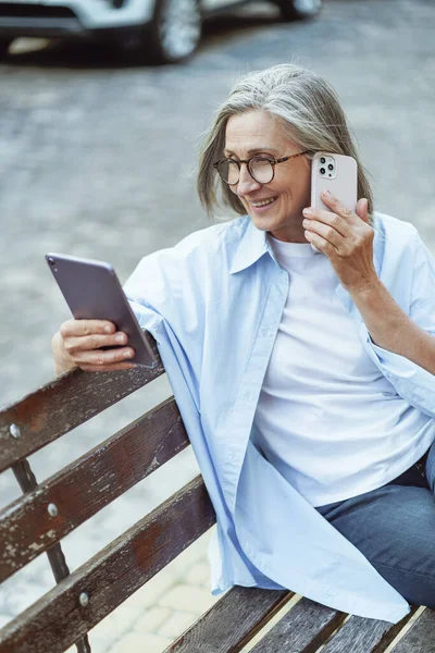 Wanita Senior Mencari Informasi Secara Online Dan Berbicara Telepon Genggam — Stok Foto