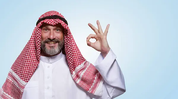 Homem Árabe Alegre Confiante Sorri Calorosamente Mostra Sinal Contra Fundo — Fotografia de Stock