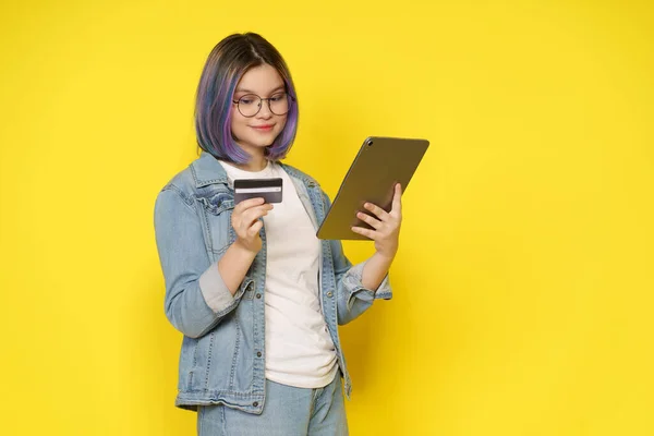 인터넷에서 스토어에서 온라인 소녀는 노란색 높이에 태블릿 Pc에서 온라인으로 상품을 스톡 이미지