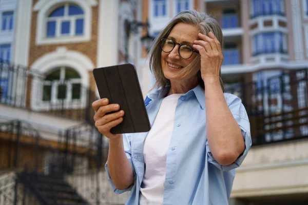 Uma Mulher Usando Óculos Está Frente Prédio Segurando Tablet Suas Imagens Royalty-Free