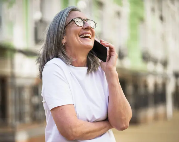 Een Vrouw Met Een Bril Praat Haar Mobiele Telefoon Stockfoto
