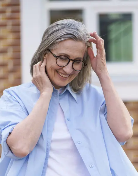 Een Oudere Vrouw Met Een Bril Een Blauw Shirt Stockfoto