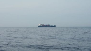 Cargo ship on sea horizon. Shot with copyspace