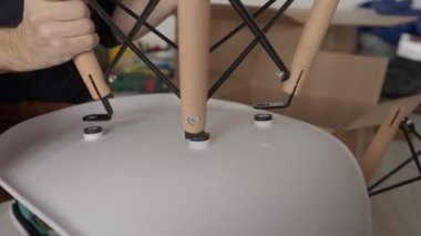 Yeni dairede sandalyeyi monte eden adamın düşük açılı görüntüsü.