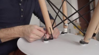 Yeni dairede sandalyeyi monte eden adamın düşük açılı görüntüsü.