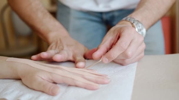 Zbliżenie Ujęcie Terapeuty Ręcznego Stosującego Taśmę Kinezyjską Dłoni Kobiety — Wideo stockowe