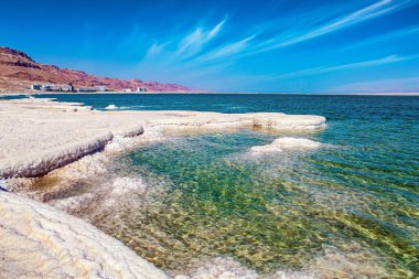 İsrail 'deki drenajsız tuz gölü, dünyanın en tuzlu gölü. Suyun yüzeyinde, buharlaşmış tuz tuhaf kristal şekiller oluşturur. Sıcak kış şubat ayı. Eşsiz Ölü Deniz. 