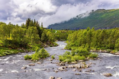 Yaz. Batı Norveç. Hardangerfjord 'un başlangıcı. Güçlü bulutlar fiyordun su yüzeyine yansıyor..  