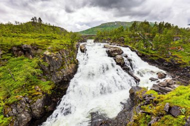 Voringsfossen Norveç 'in en ünlü çağlayan şelalelerinden biridir. Norveç 'te soğuk Temmuz yağmurlu. Şelale dar ve derin bir vadiye düşüyor.. 