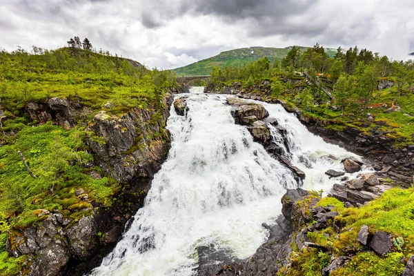 ヴォリングスフォッセンはノルウェーで最も有名な滝の一つです ノルウェーで7月の雨の寒さ 滝は狭く深い絵のように美しい峡谷に落ちます — ストック写真