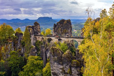 Eski köprü Bastei devlet tarafından korunan mimari bir anıttır. Bulutlu bir sonbahar günü. Bastei 'nin resimli kumlu uçurumları. Almanya. Sakson İsviçre 'ye romantik bir gezi. 