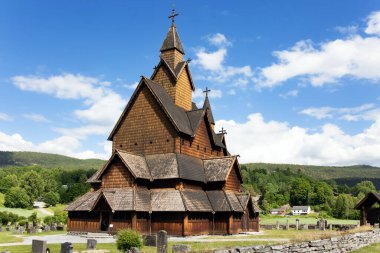 Yazın Norveç 'e seyahat et. Kilise avlusundaki antik mezarlık. Heddal 'daki Stave Kilisesi hayatta kalan en büyük çerçeve kilisesidir.. 