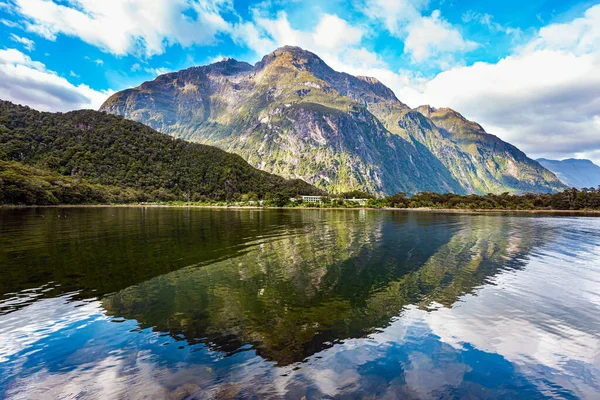 山はフィヨルドの滑らかな水に反映されています 最も有名で絵のようなフィヨルドは氷河の起源であるミルフォードサウンドです フィールドランド公園 ニュージーランドだ — ストック写真