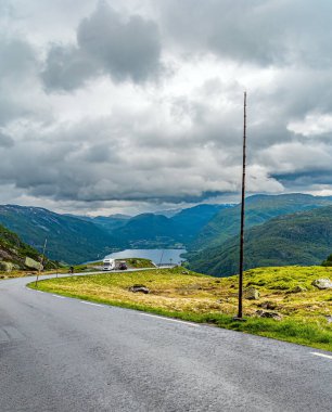 520 nolu yolda karavanla seyahat ediyorum. Norveç 'te soğuk bir yaz. Bisikletçiler ıslak bir yola çıkmak için mücadele ederler.. 