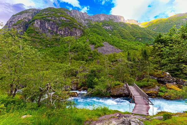 吊桥横跨溪流 从Bondhuswatnet湖中流出的湍急的高山冷水流 伟大的挪威 夏草的翡翠绿色 — 图库照片