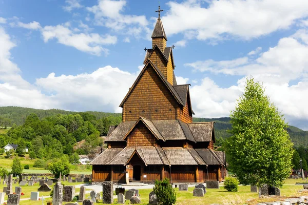 Travel to Norway in summer. The oldest and most beautiful church in Norway in Heddal. The Stave Church is crowned with crosses. Ancient cemetery in the churchyard