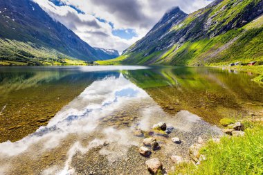Norveç 'e yaz gezisi. Güzel ve sakin Eidsvatnet Gölü. Pürüzsüz göl suyu dağları yansıtır. Temmuz ayında güneşli bir gün. Kuzey Avrupa. 