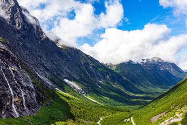 Dev bir kanyonun yeşil çimenli yamaçlarında parlak gölgeler. Norveç dağlarında güneşli bir yaz günü. Fotoğraf bir İHA 'dan çekildi. Ünlü 