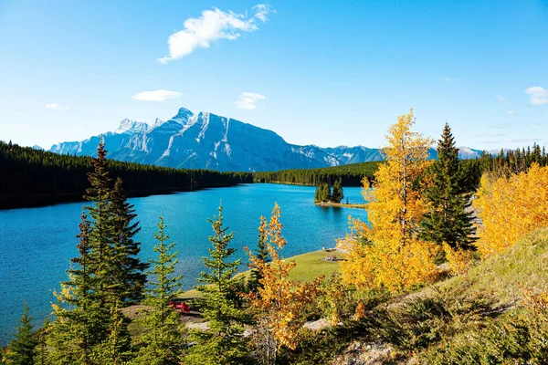 Magnificent Banff Park, the famous Rocky Mountains, Two Jack Lake. Small picturesque island off the coast is overgrown with pine trees. Autumn Indian Summer in Canada