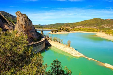 Magnificent scenic dam collects the water of the Gallego River. Wonderful autumn day. La Jolla de Huesca. Indian summer in northern Spain