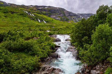 The  waterfall. Scenic road in the mountains of Western Norway. Beginning of the Hardangerfjord. Scandinavia. Summer, July