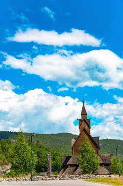 Travel to Norway in summer. The beautiful church in Norway in Heddal. The Stave Church is crowned with crosses. Ancient cemetery in the churchyard