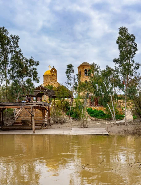 Greek Orthodox Church of John the Baptist. Place of the Baptism of Jesus Christ on of the Jordan River in Israel - Bethabara. Smooth yellow water of the Jordan River