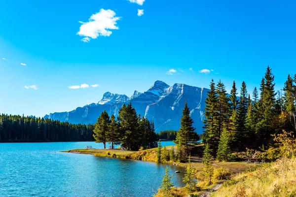 Travel to Canada. Magnificent Banff Park, the famous Rocky Mountains, Two Jack Lake. Huge glacial lake reflects the sun and cloud. Autumn Indian Summer in Canada