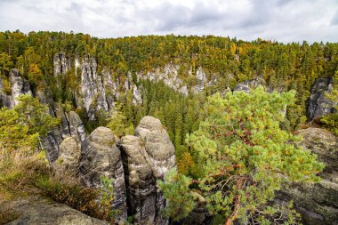 Germany. Romantic trip to Saxon Switzerland. The picturesque sandy cliffs of Bastei. The old bridge Bastei is architectural monument protected by the state. Cloudy autumn day. 