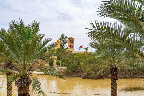Palm trees on the banks of the Jordan River. Greek Orthodox Church of John the Baptist. Place of the Baptism of Jesus Christ on of the Jordan River in Israel - Qasr el Yahud.