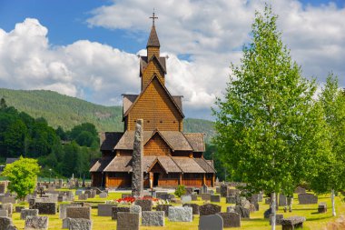 The beautiful church in Heddal, Norway. The Stave Church is crowned with crosses. Ancient cemetery in the churchyard. Travel to Norway in July