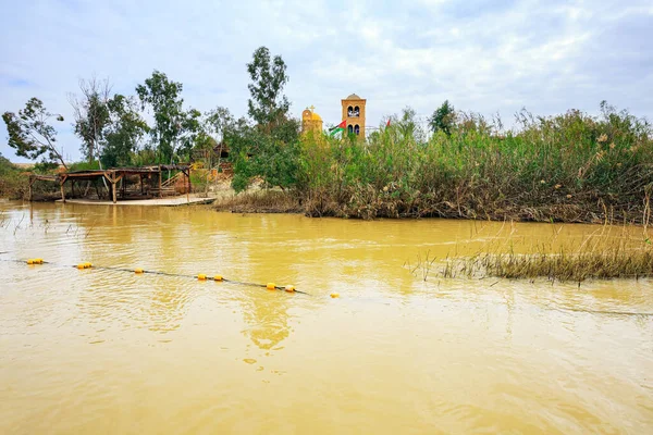 Yellow water of the wide Jordan River. Place of the Baptism of Jesus Christ in Israel - Qasr el Yahud. The Jordan River - state border between Israel and Jordan.