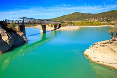 Picturesque cliffs, bridge and backwater. Indian summer in northern Spain. The La Penia Reservoir collects the waters of the Gallego River. La Jolla de Huesca. Wonderful autumn day.