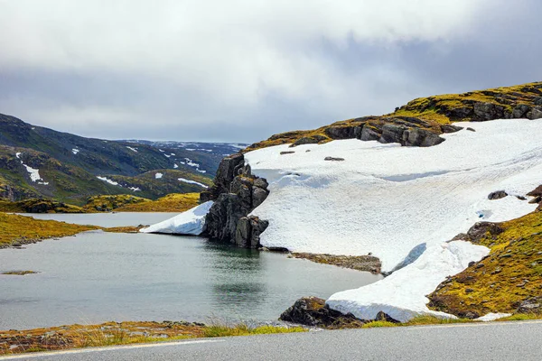 stock image The cold snowfields and sharp stone placers. The cold water of the lake is covered with ice floes. Gorgeous 